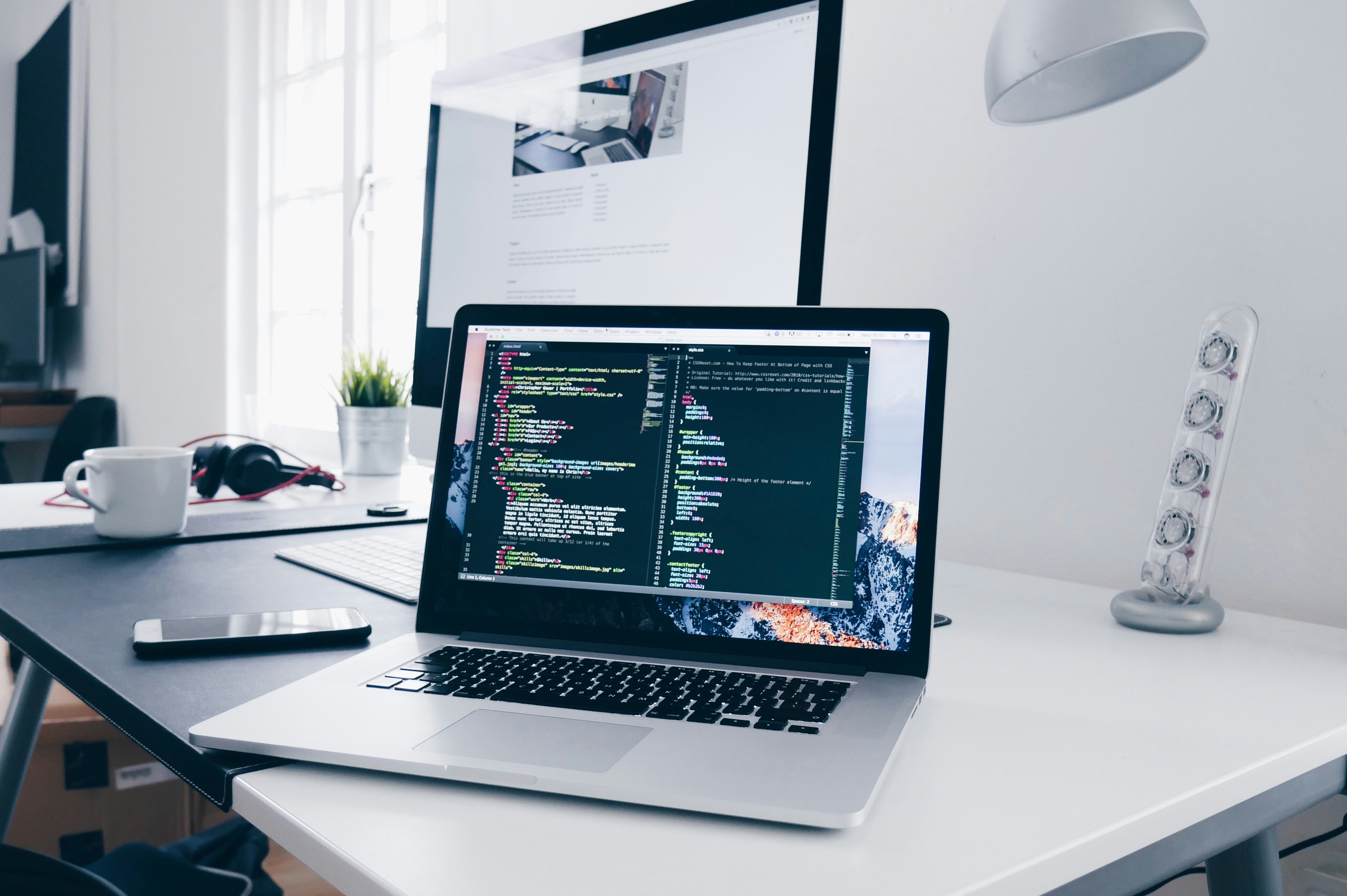 Laptop workstation showing code and digital product work