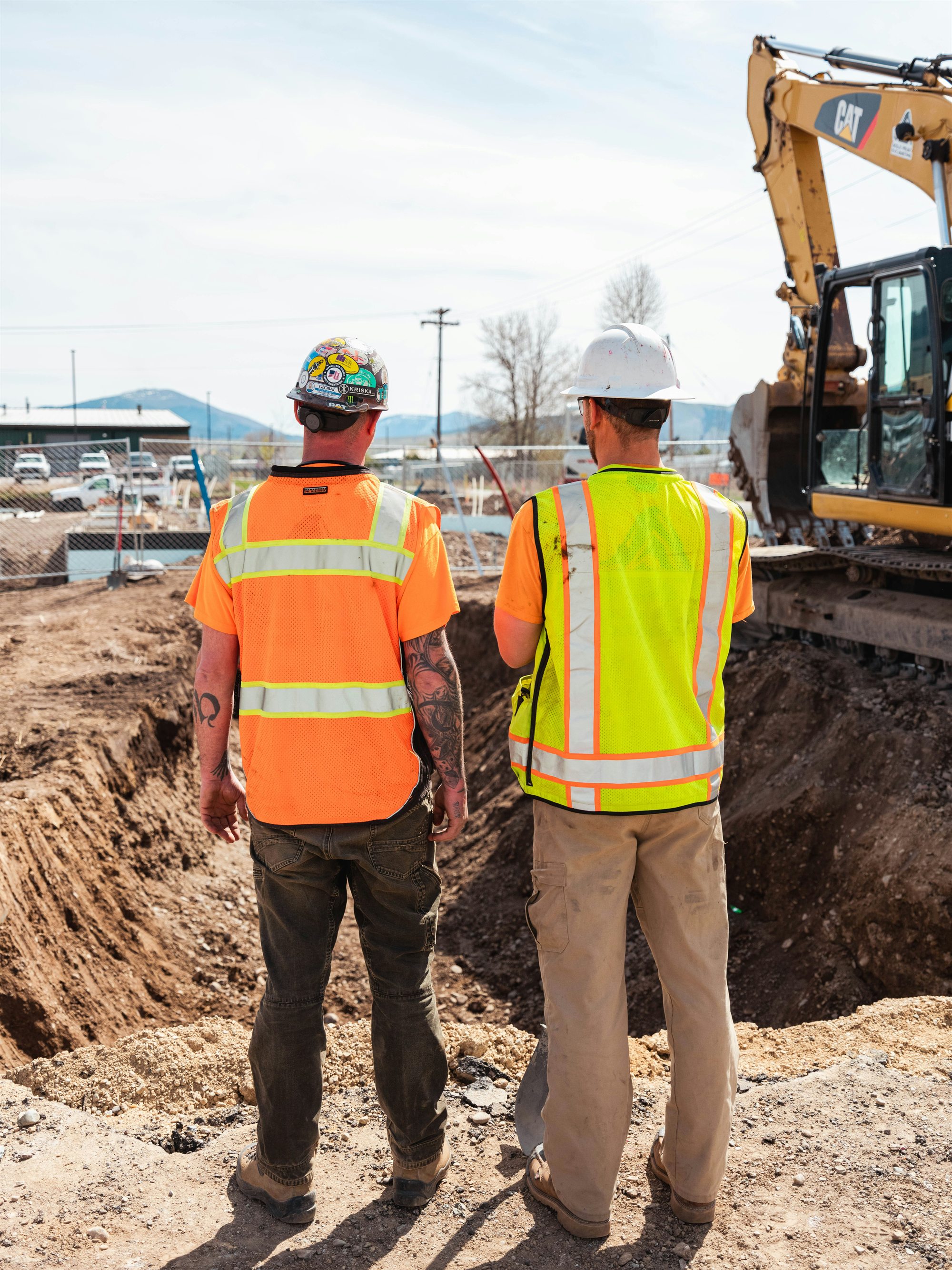 Construction crew coordinating beside equipment