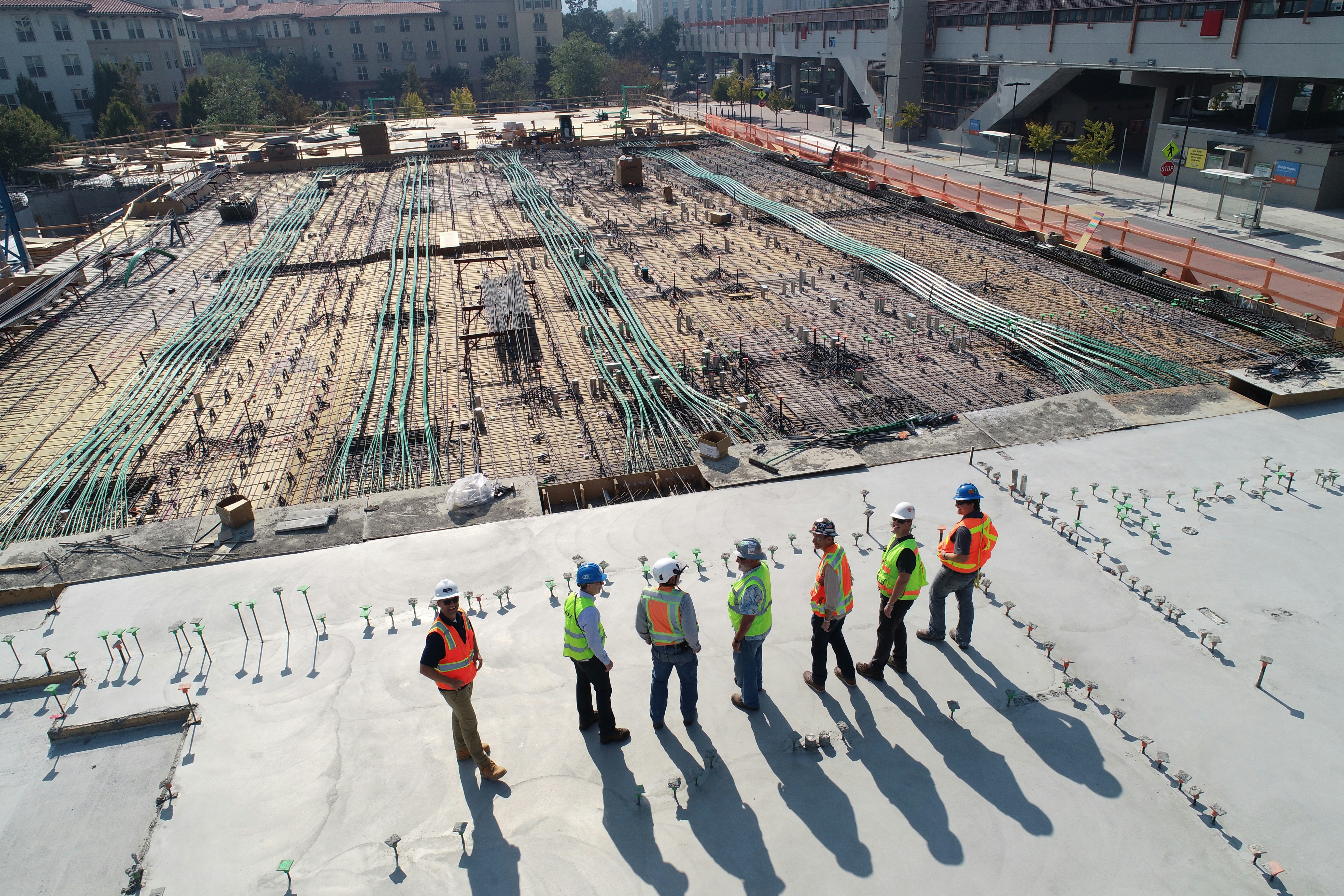 Construction team reviewing building systems rough-in from above